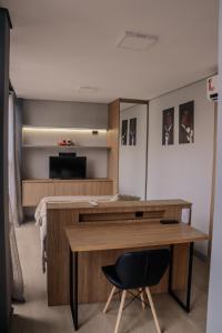 a room with a desk with a chair and a television at TBG Studios in Curitiba