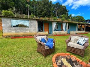 a yard with two chairs and a fire place at Encanto da Paz in Miracatu