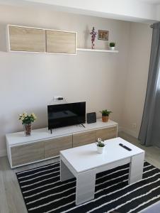 a living room with a tv and a white table at Piso Gallega in Finisterre