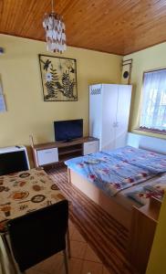 a bedroom with a bed and a table and a chair at Oázis Apartman in Harkány