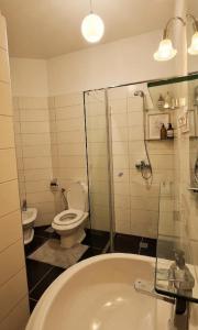 a bathroom with a sink and a toilet and a tub at Marina Chic Apartment in Vlorë