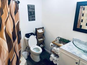 a bathroom with a toilet and a sink at Serenity home in Laplace +8 photos