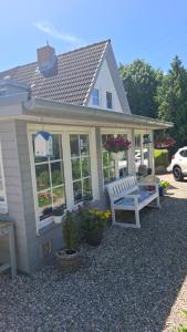 a house with a bench and flowers in front of it at Cosy Home in Scharbeutz