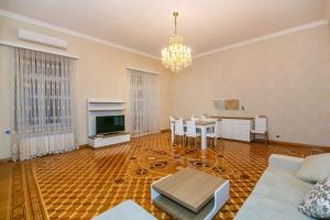 a living room with a couch and a table and a television at 3 Bedrooms Apartment ın Center in Baku