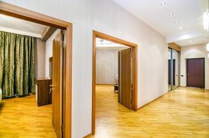 an empty room with two open doors and wooden floors at 3 Bedrooms Apartment ın Center in Baku