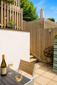 a bottle of wine and two glasses on a table at Meadowvine - By Rowes Retreats in Penryn