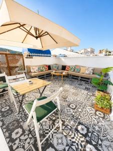 a patio with a table and chairs and an umbrella at Hil Ada 1 in Bozcaada