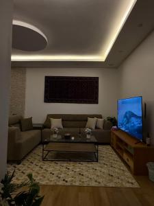 ein Wohnzimmer mit Sofa und Fernseher in der Unterkunft شقة غيم in Abha