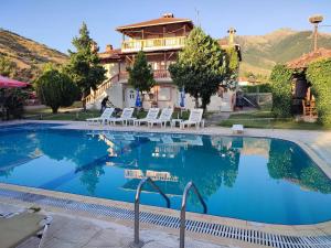 a pool with chairs and a house in the background at Villa Platythea in Platy