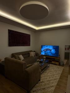 ein Wohnzimmer mit Sofa und Flachbildfernseher in der Unterkunft شقة غيم in Abha + 1 Foto