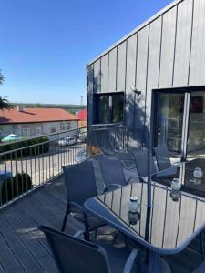 a patio with a table and chairs on a balcony at WidziMisie Summer Apartament in Dominice