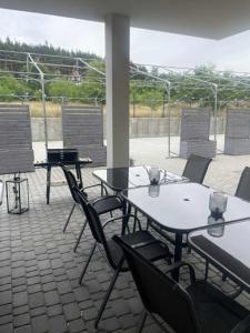 a group of tables and chairs on a patio at WidziMisie Summer Apartament in Dominice