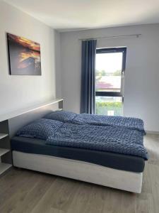 a bedroom with a large bed with a window at WidziMisie Summer Apartament in Dominice