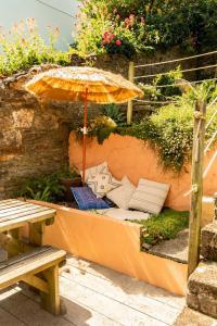 a patio with an umbrella and chairs and a bench at Tide View Townhouse - By Rowes Retreats in Falmouth +72 photos