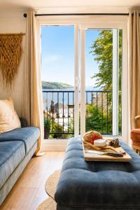 a living room with a couch and a large window at Tide View Townhouse - By Rowes Retreats in Falmouth