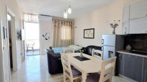 a kitchen and a living room with a table and a refrigerator at Marina Chic Apartment in Vlorë +8 photos