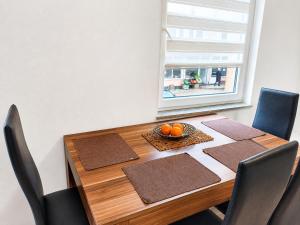 a dining room table with chairs and a window at Rose Apartment in Jajce