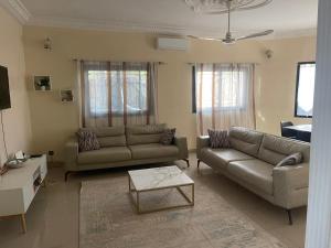 a living room with two couches and a coffee table at Soleil ak Jàmm in Mbour
