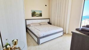 a small bedroom with a bed and a window at Marina Chic Apartment in Vlorë