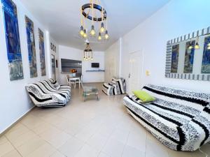 a living room with two beds and a table at Hébergement H in Ngaring +6 photos