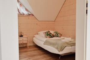 a small room with a bed in a wooden cabin at Zdrojowe wzgórze in Rymanów-Zdrój
