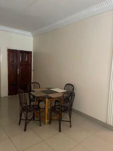 a dining room with a table and chairs and a door at Soleil ak Jàmm in Mbour +4 photos