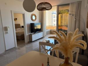 a living room with a television and a living room with a table at Lux Apartment Vidovic II in Rafailovici