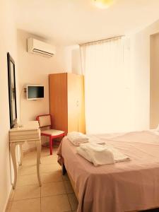 a bedroom with a bed and a desk and a chair at Nese Otel in Çeşme