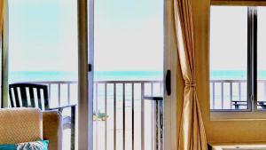 a room with a view of the ocean from a balcony at Boardwalk Oceanfront Condo with Panoramic Views in Virginia Beach