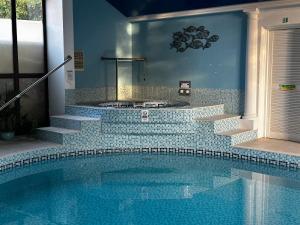 a bathroom with a swimming pool and a tub at Smugglers Cottage converted Barn with Pool & Jacuzzi NR Lyme Regis in Whitchurch Canonicorum +24 photos