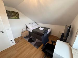 a small room with a bed and a desk with a computer at Toukam's Apartment, near Ingolstadt in Stammham