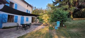 a patio with a table and chairs next to a house at Ecrin de Verdure in Anneyron