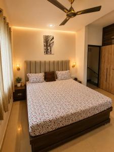 a bedroom with a bed and a ceiling fan at Vishwakarma Niwas Jacuzzi Villa with Pool in Thane