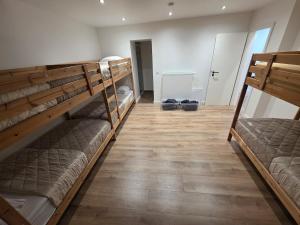 two bunk beds in a room with a wooden floor at Home cinema in Liège