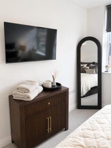 a bedroom with a dresser and a large mirror at Luxury Central Solihull Apt - King Bed, Sofa Bed & 2 Parking Spaces in Solihull