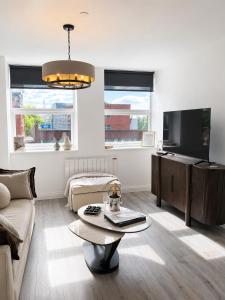 a living room with a couch and a tv at Luxury Central Solihull Apt - King Bed, Sofa Bed & 2 Parking Spaces in Solihull