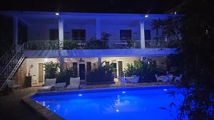 a house with a swimming pool at night at Doña Mayra Aparta Hotel in Las Terrenas
