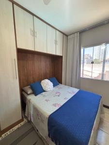 a bedroom with a bed with blue sheets and a window at Casa Costa do Sol completa, 100m da praia in Macaé +47 photos
