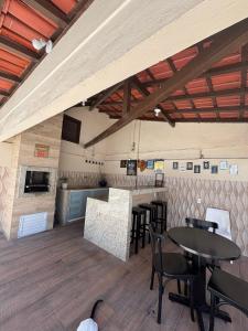 a restaurant with tables and chairs in a room at Casa Costa do Sol completa, 100m da praia in Macaé