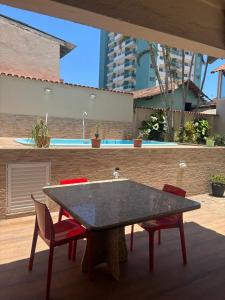 a table and four chairs on a patio at Casa Costa do Sol completa, 100m da praia in Macaé