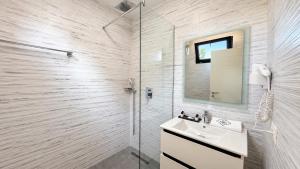 a white bathroom with a sink and a shower at 313 Villa City Center in Tirana