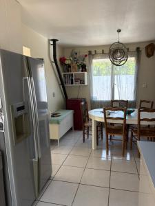 a kitchen with a refrigerator and a table with chairs at Villa playa in Valras-Plage