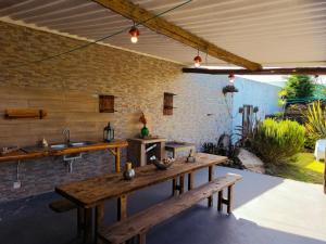 an outdoor kitchen with a wooden table and benches at De Baixo Da Ponte in Biscoitos