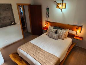 a bedroom with a large bed with a wooden headboard at De Baixo Da Ponte in Biscoitos