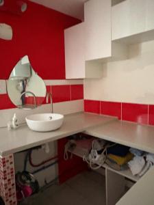 a bathroom with a sink and a red wall at Villa playa in Valras-Plage