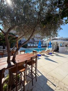a wooden table and chairs under a tree next to a pool at Accommodation Royal Azur in Dobra Voda +36 photos