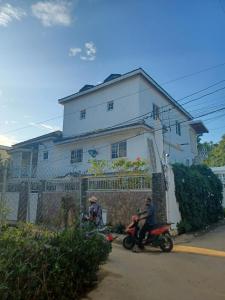 two people riding motorcycles in front of a house at Doña Mayra Aparta Hotel in Las Terrenas