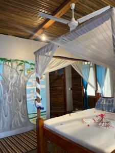 a bedroom with a bed with a painting on the wall at Mafia Beach Bungalows sea view in Utende