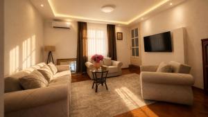 a living room with two couches and a table at Maison Des Oliviers in Herceg-Novi