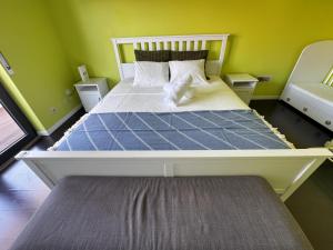 a large bed in a room with green walls at Cascais House - Pool in Parede